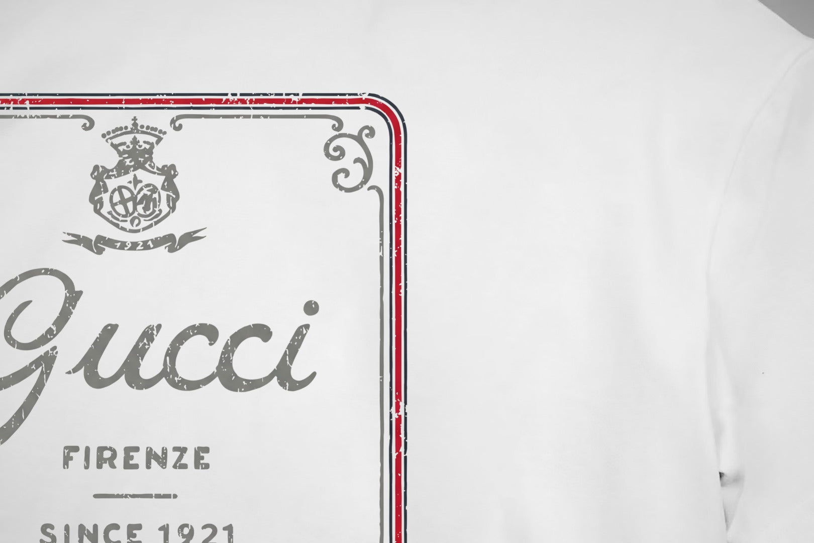 White Gucci T-shirt front logo close-up with red border and gray 'Gucci' print