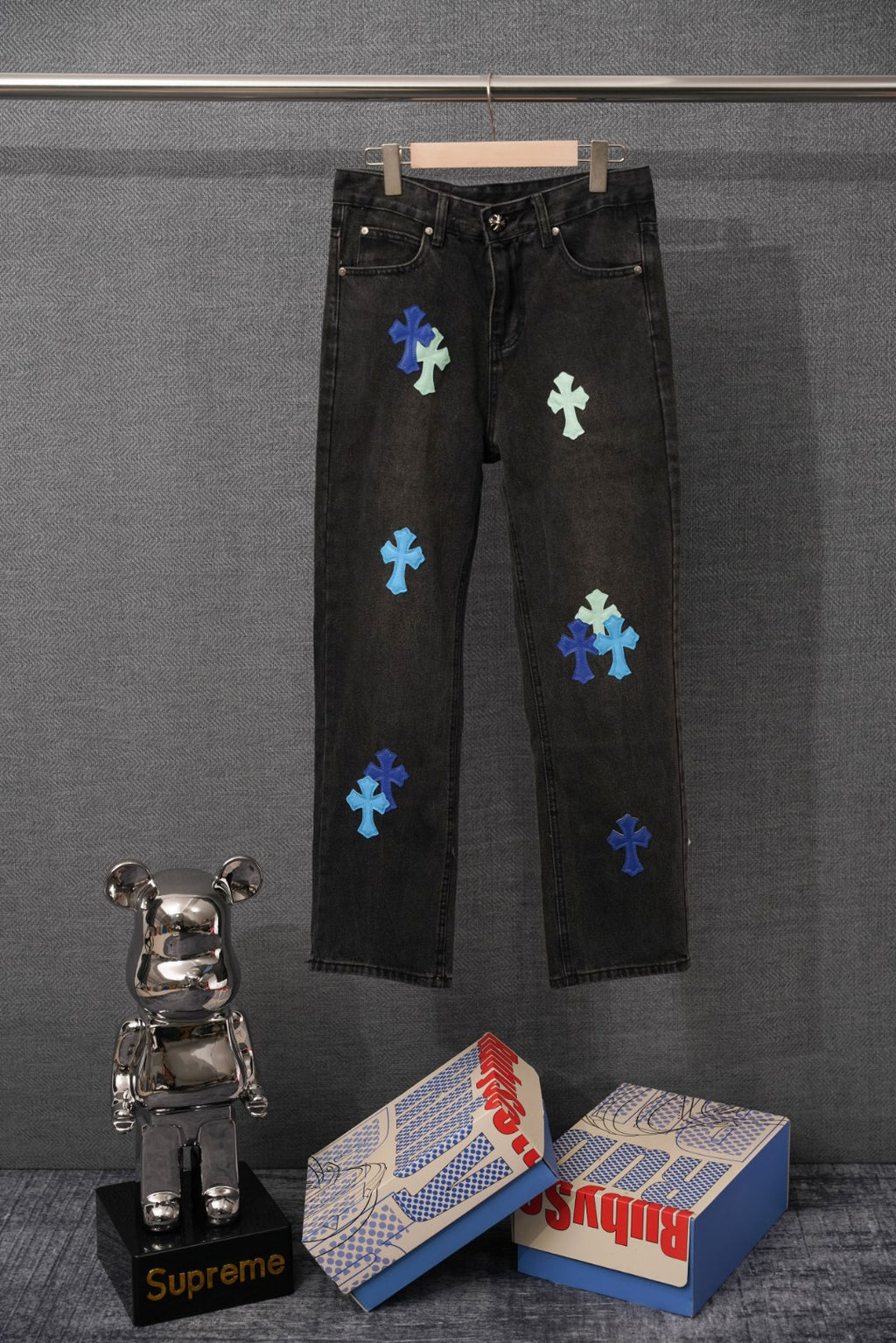 Black denim pants with multicolor cross patches, button fly and belt loops