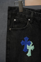 Black denim pants pocket with blue and light green cross patch