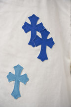 White denim fabric with large blue cross patch print details