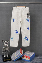 White denim pants with blue cross print and belt loops, front view