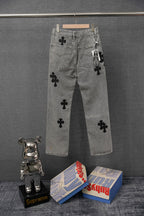 Gray denim pants with black cross patches on front and thigh