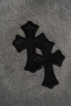 Black pants with cross-shaped fabric patch at knee