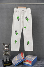 White denim pants with green cross-like graphic patches and black outlines, straight leg