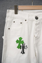 White denim pants with green cross graphic and front belt loops
