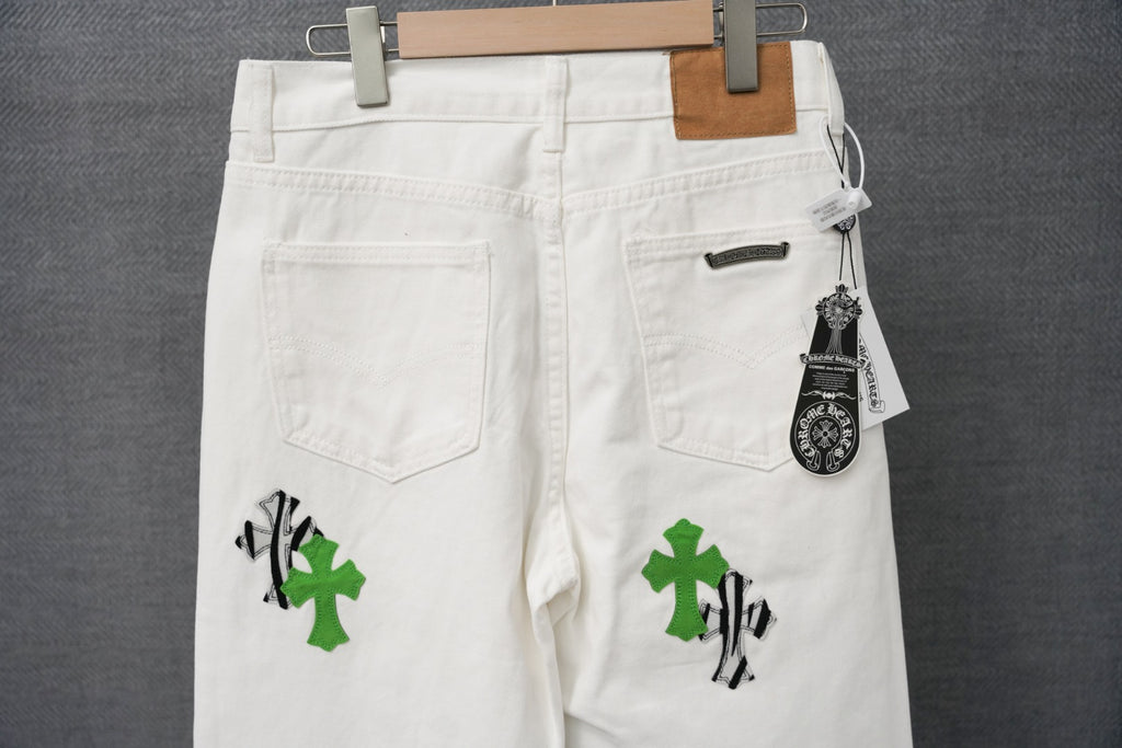 White pants with green cross graphic, front pockets, and hanging size tag