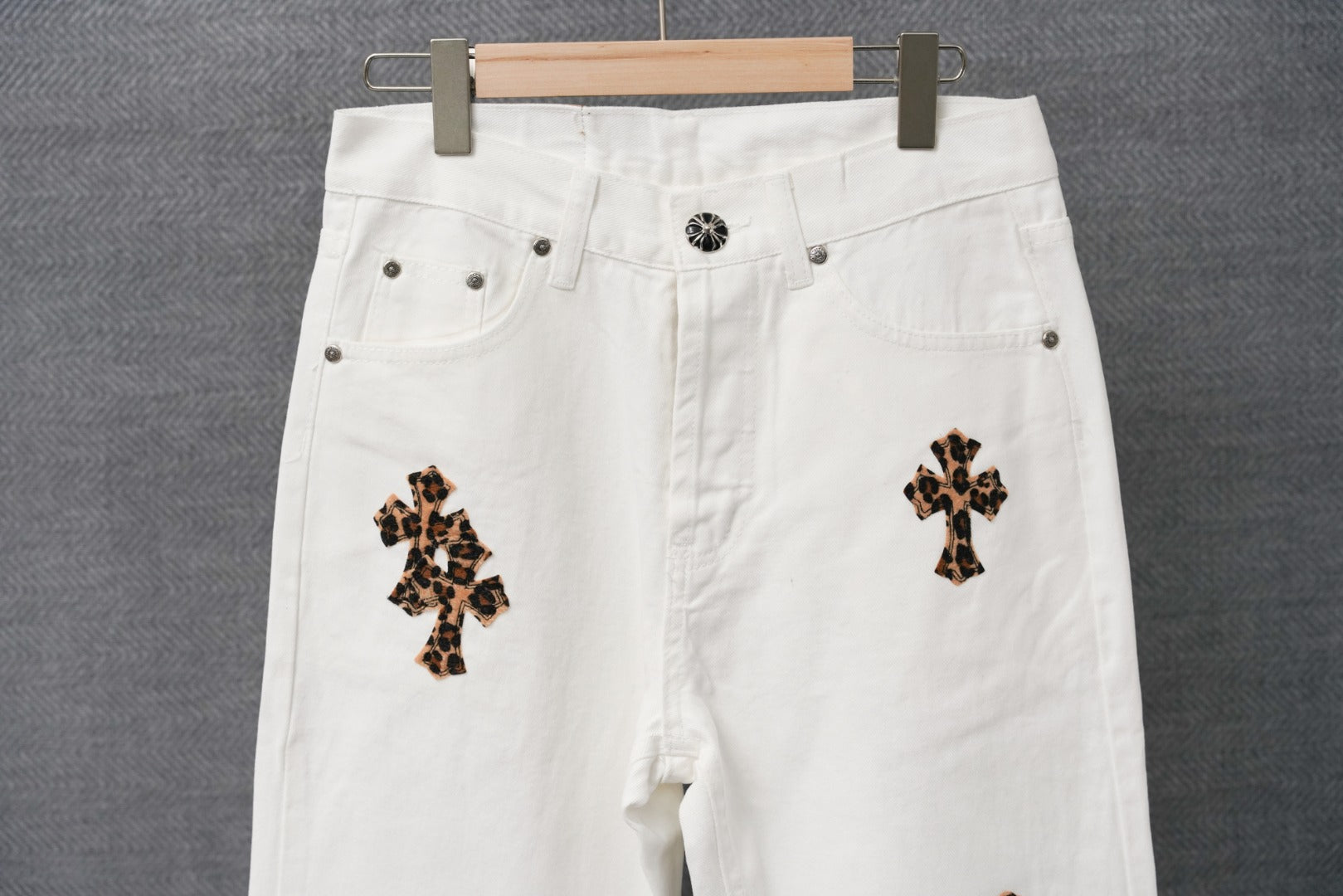 White denim pants with button waistband and leopard cross patch details