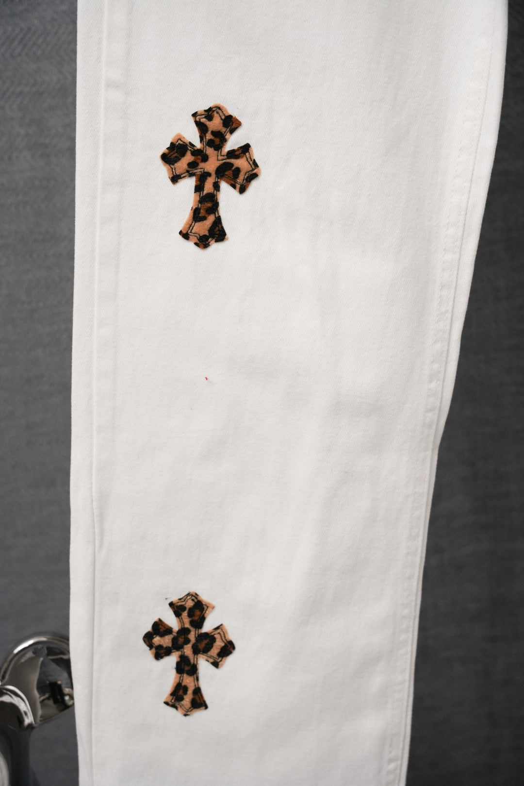 White pants with leopard-print cross patch on upper and lower leg