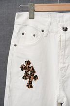 White pants close-up with belt loops and a leopard-print cross patch on the thigh