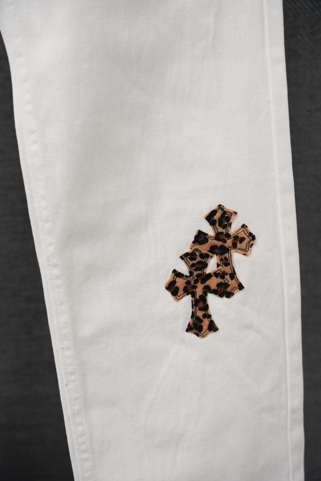 White pants with leopard-print cross patch on the side leg