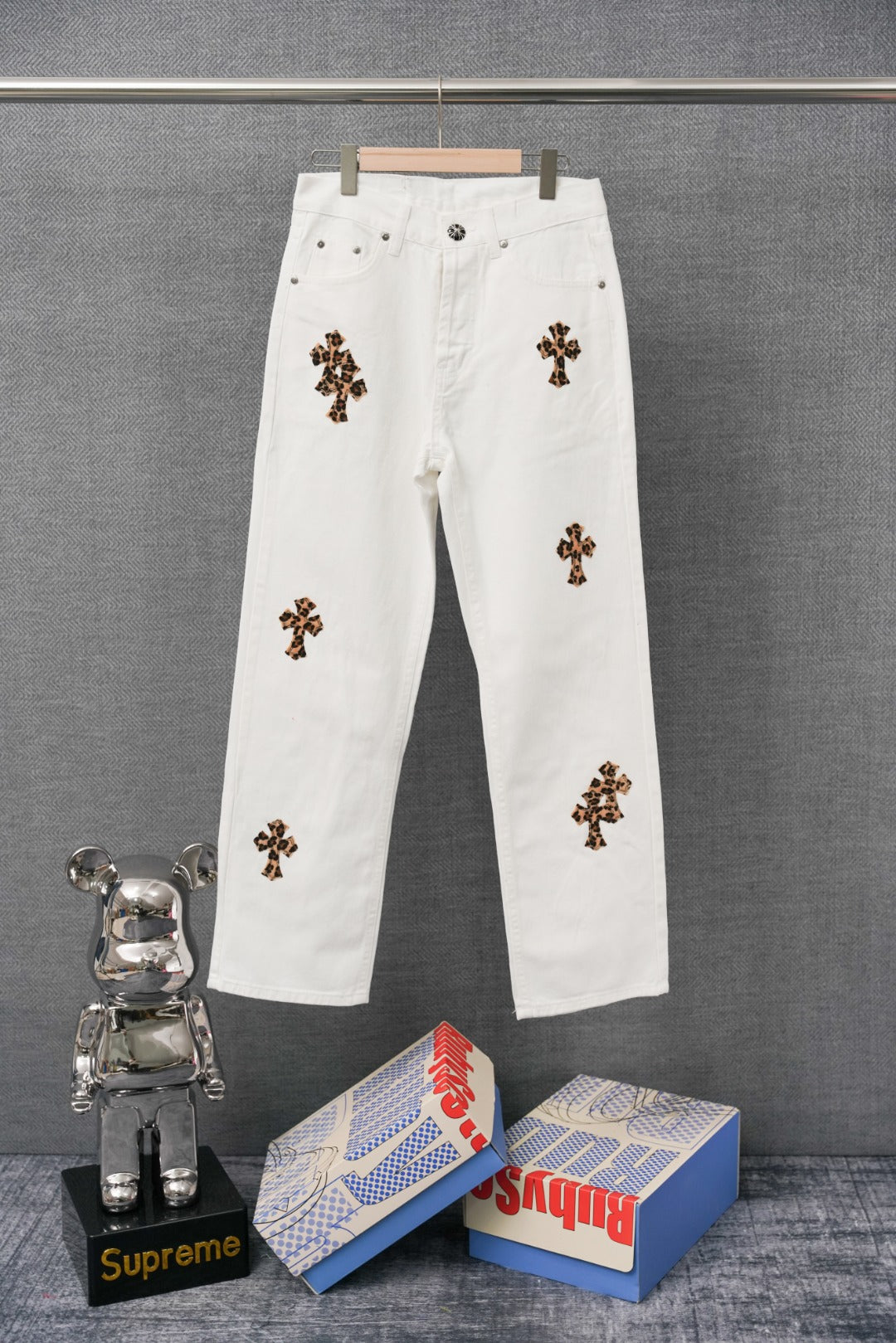 White denim pants with leopard-print cross patches on the legs