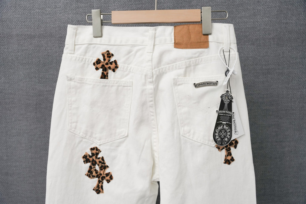 White denim pants with leopard cross patches and a branded pocket tag