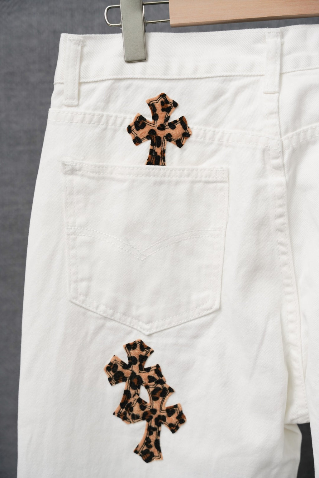 White pants with leopard-print cross patches and front pockets
