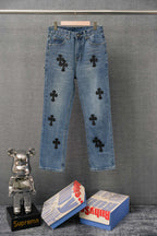 Light blue denim pants with black cross patchwork detailing on legs