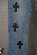Light blue denim pants side view with black cross patches spaced on leg