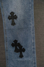 Blue denim Chrome pants leg with two black cross patches.