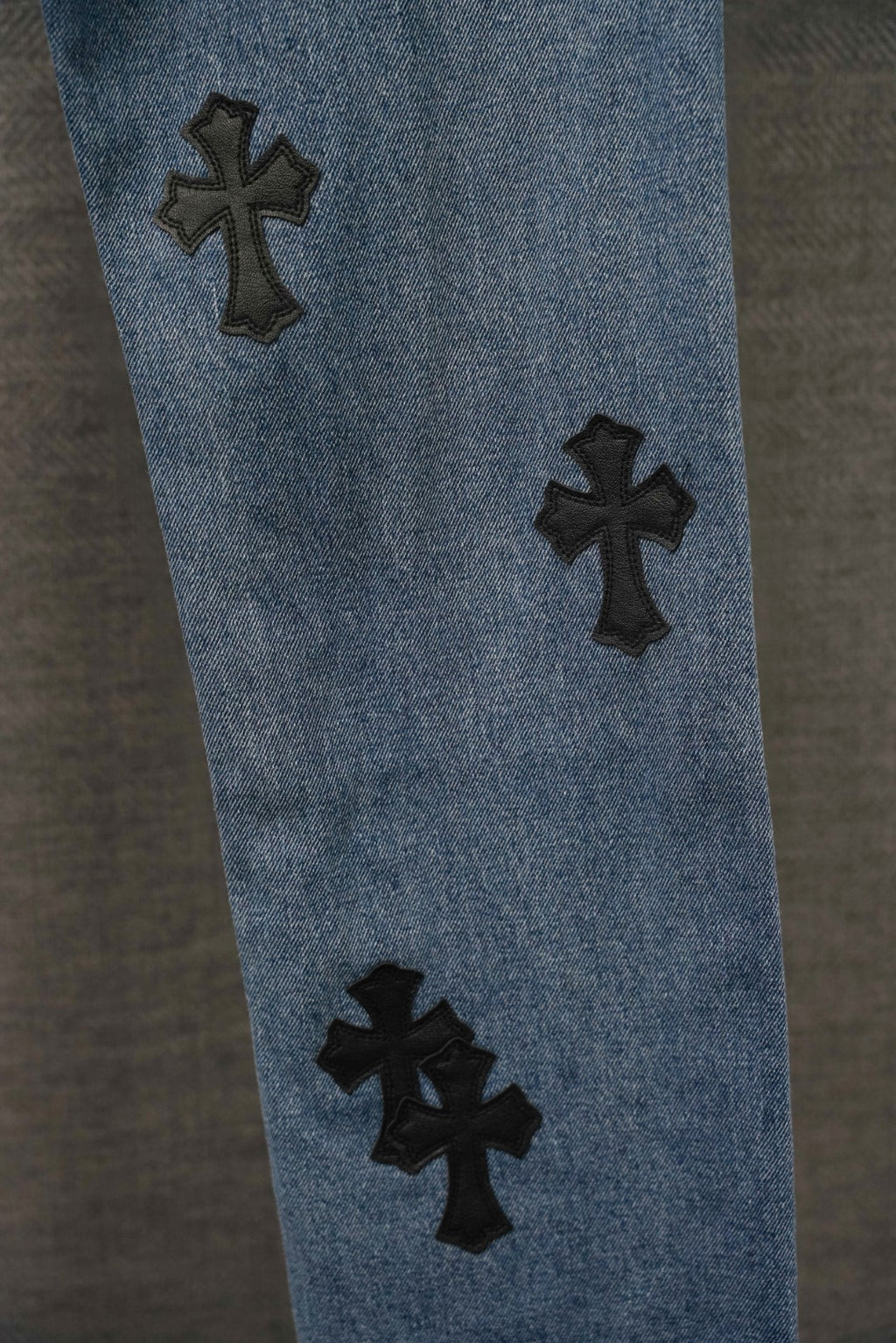 Blue denim Chrome pants leg with three black cross patches, spaced apart.