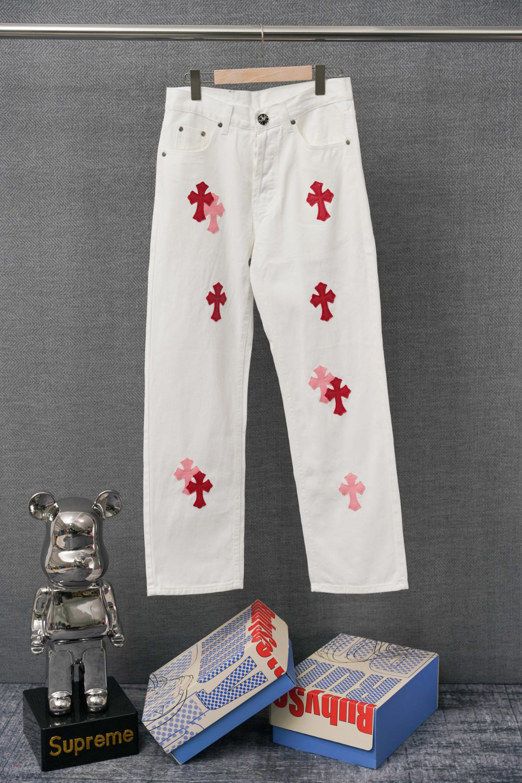 White pants with red cross appliques, button-front and five-pocket style