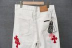 White pants with red cross applique, belt loops, and hanging brand tag