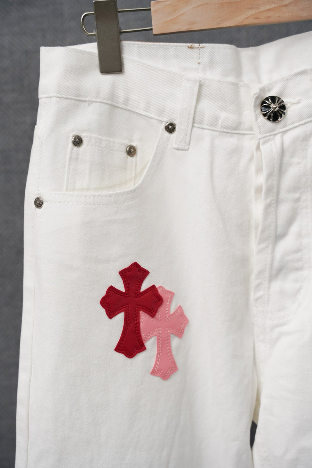 White pants with red cross applique on leg and metal rivet pocket corners