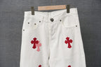 White pants with button fly and red cross patches on the thighs
