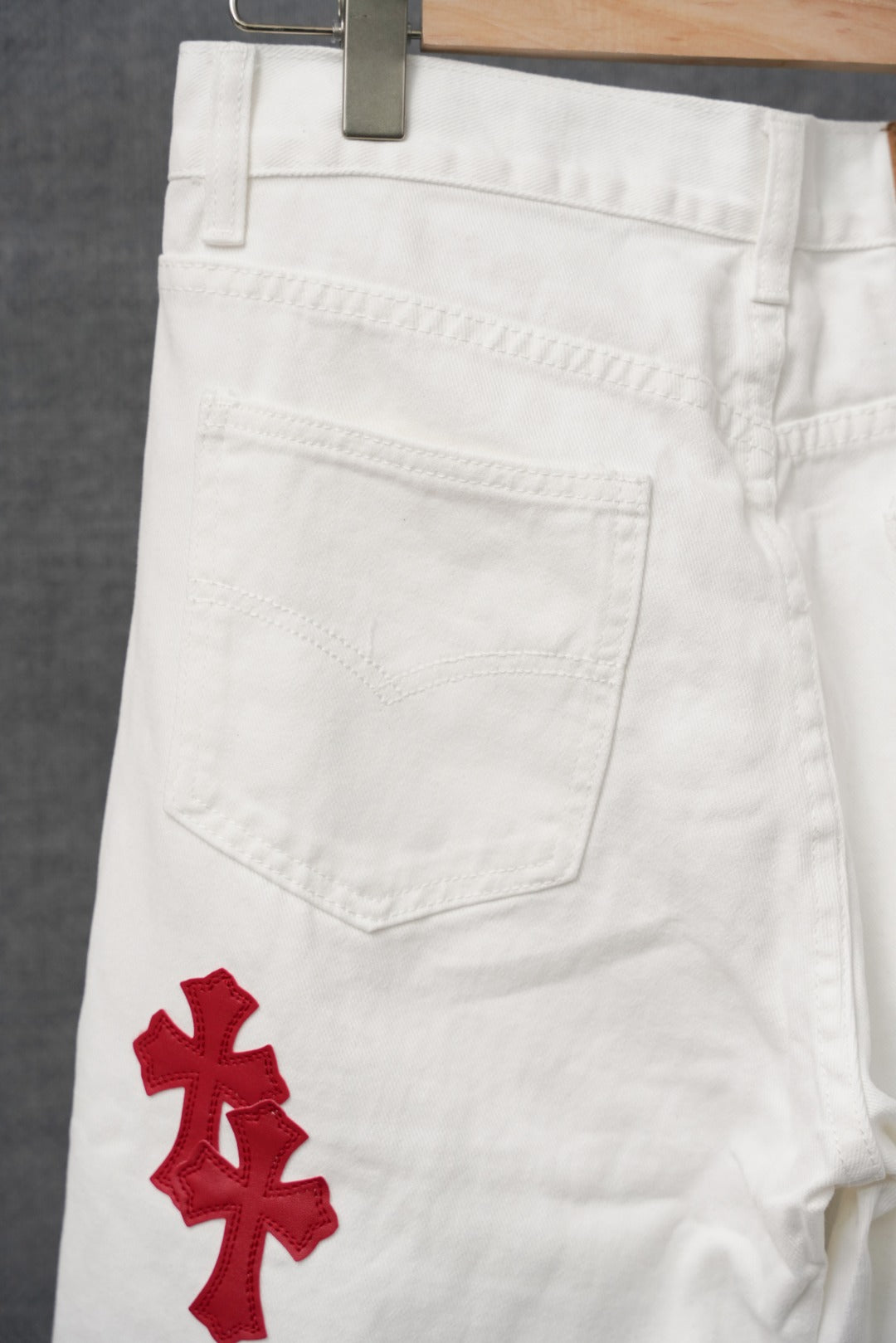 White pants with red cross appliques on the front leg and pocket