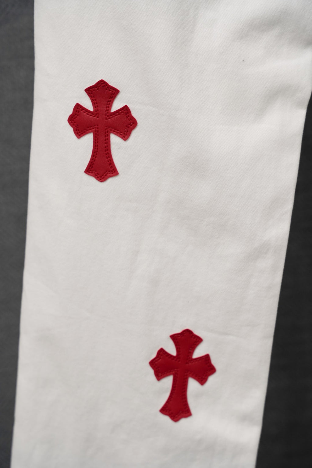 White pants with two red cross appliques on the thigh