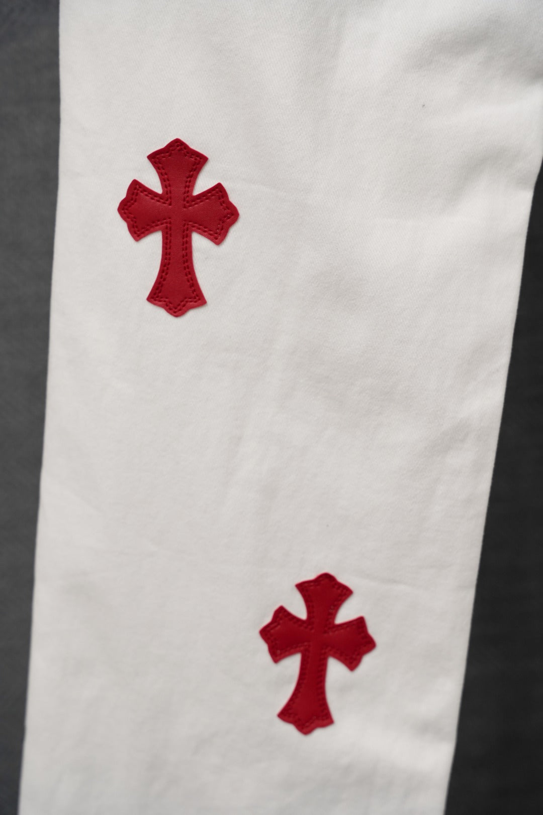 White pants with two red cross appliques on the thigh