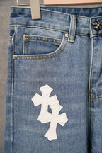 Blue denim pants close-up of waist pocket and large white cross patch