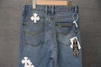 Dark blue denim pants with white cross patches, front pockets and belt loops