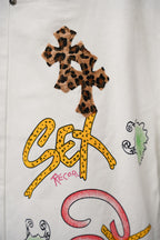 White pants with leopard-print cross patch and colorful “Sx Record” graphic