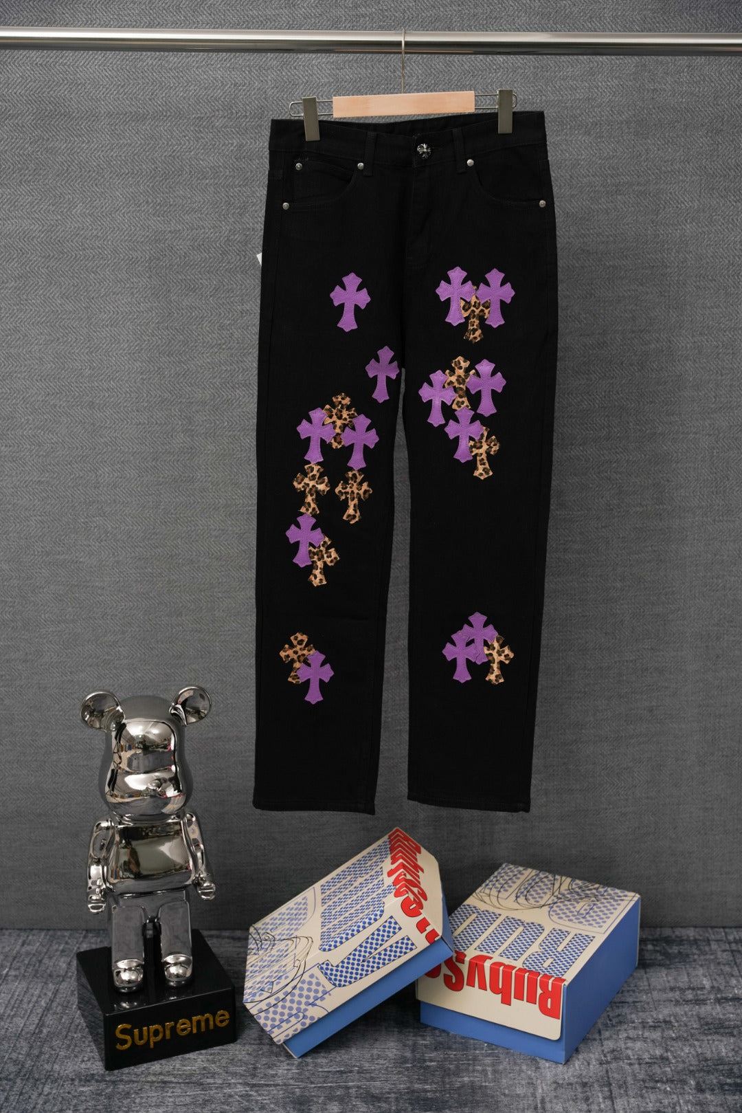 Black pants with purple and gold cross graphic patches, straight leg, button closure.
