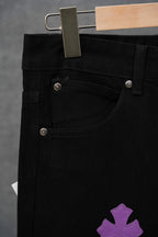 Black pants close-up: button waist, front slant pocket, metal rivet details.