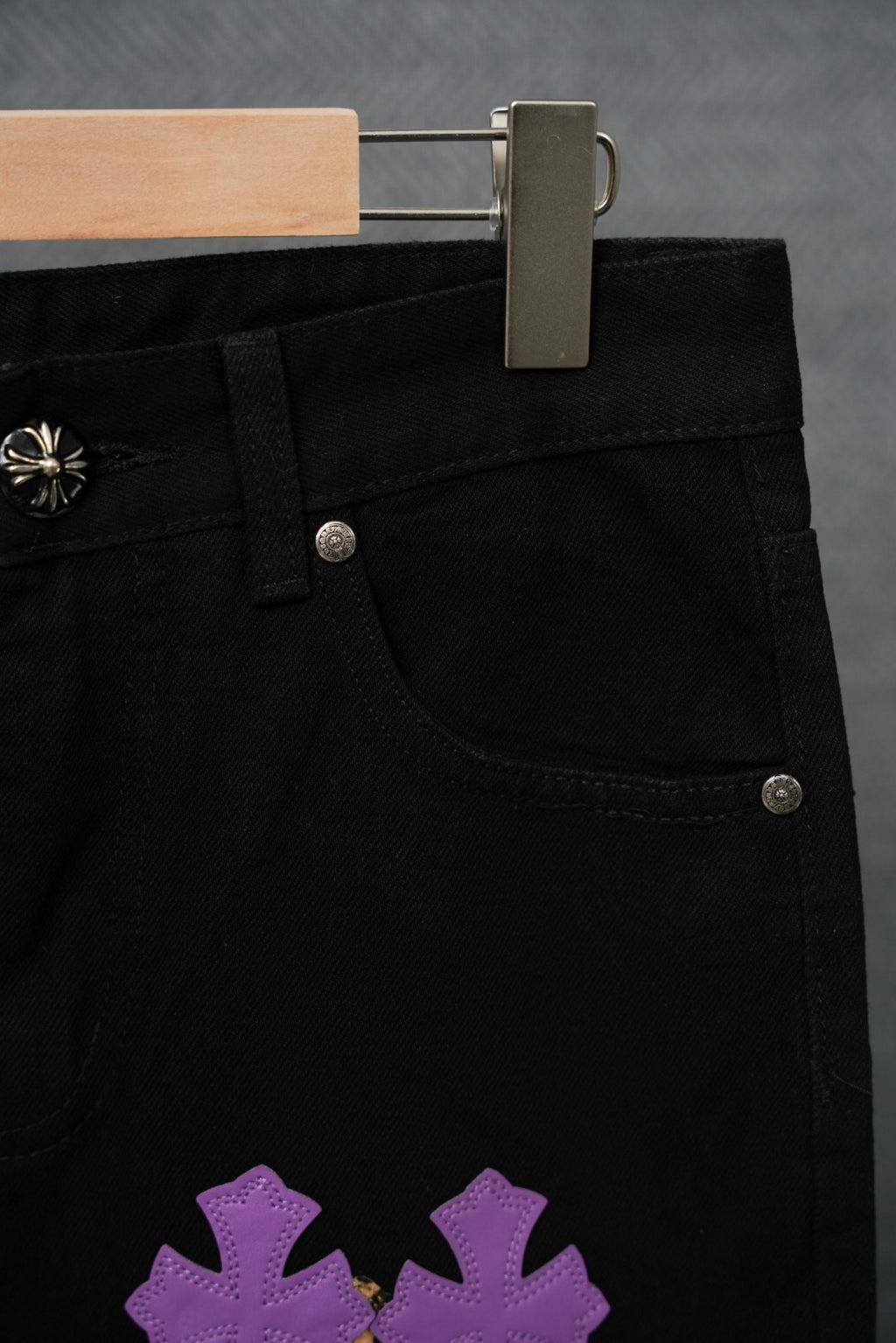 Black pants with front pocket and purple cross patch graphic on leg.