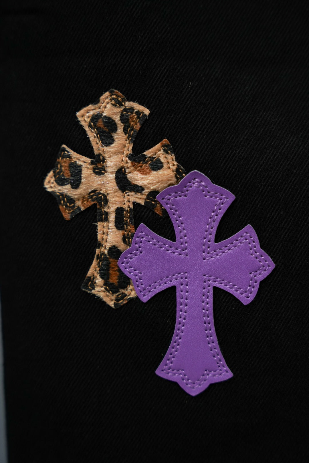 Chrome pants with leopard-pattern cross and large purple cross applique