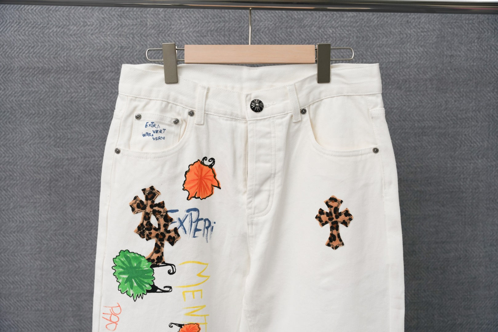Chrome pants in white with embroidered character and cross graphics near the waistband