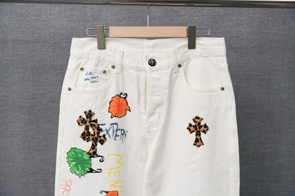White denim pants detail view with belt loops and colorful stitched patches