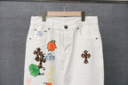 White denim pants detail view with belt loops and colorful stitched patches