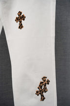 Chrome pants lower leg close-up with two leopard-print cross embroidered patches