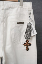 White pants with back pocket label tag and leopard-print cross appliqué
