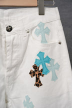 White denim pants with blue cross patches and metal button front