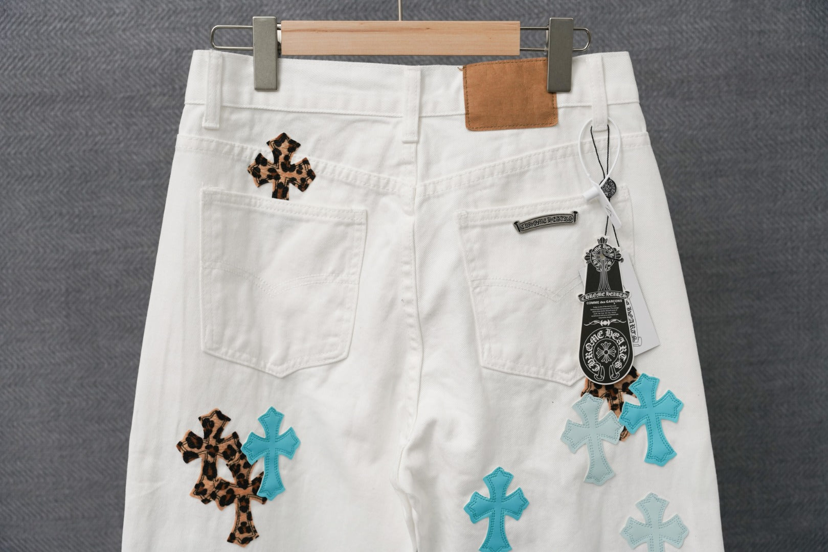 White pants with leopard and teal cross patches, front pockets and size tag