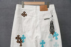 White pants with teal and leopard cross appliques, plus a dangling charm detail