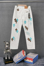 White denim pants with blue and leopard cross patches, waistband and belt loops