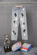Light-wash denim pants with black and white cross patches and a high-rise waistband