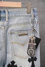Light wash denim pants with stitched cross patches and belt loop detail
