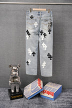 Light blue denim pants with white and black cross appliques, back view