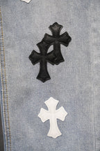 Light-wash denim close-up featuring black and white cross patches