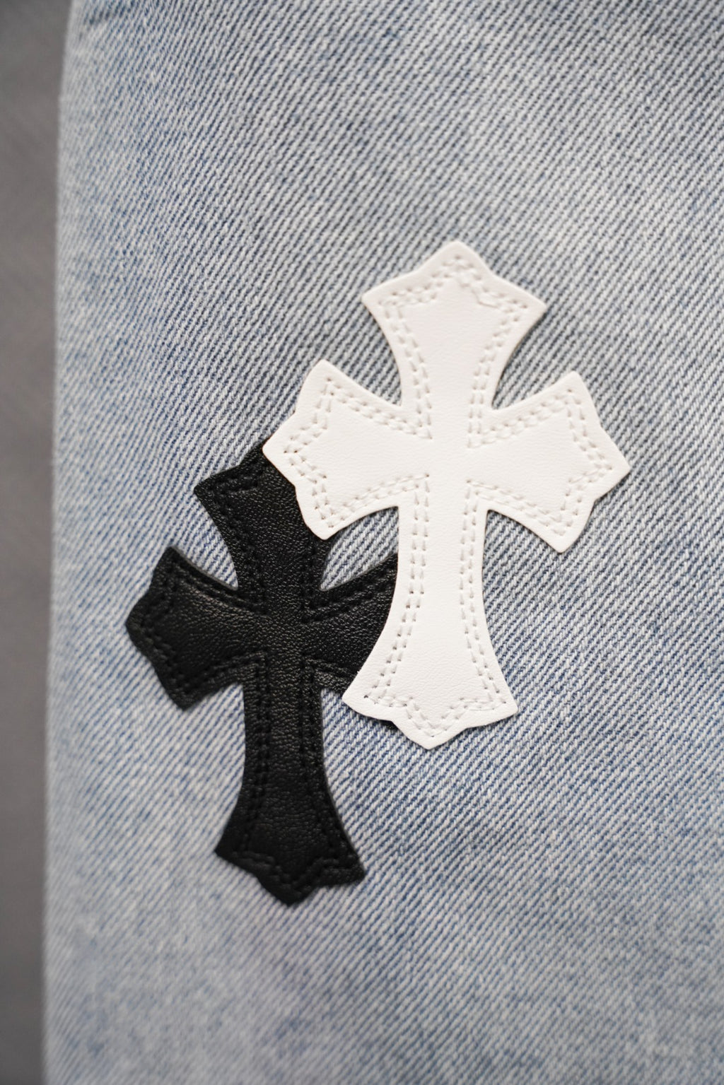 Denim pants with two cross appliqué patches in white and black
