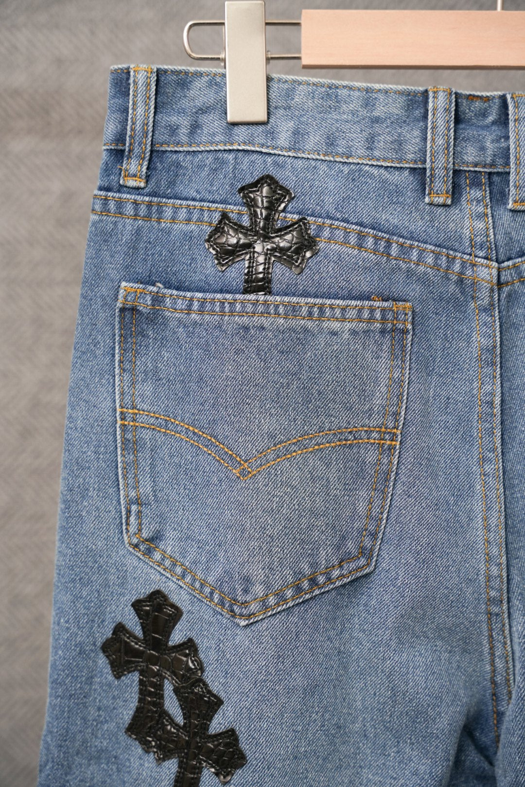 Light blue denim pants with back patch cross on upper pocket area.